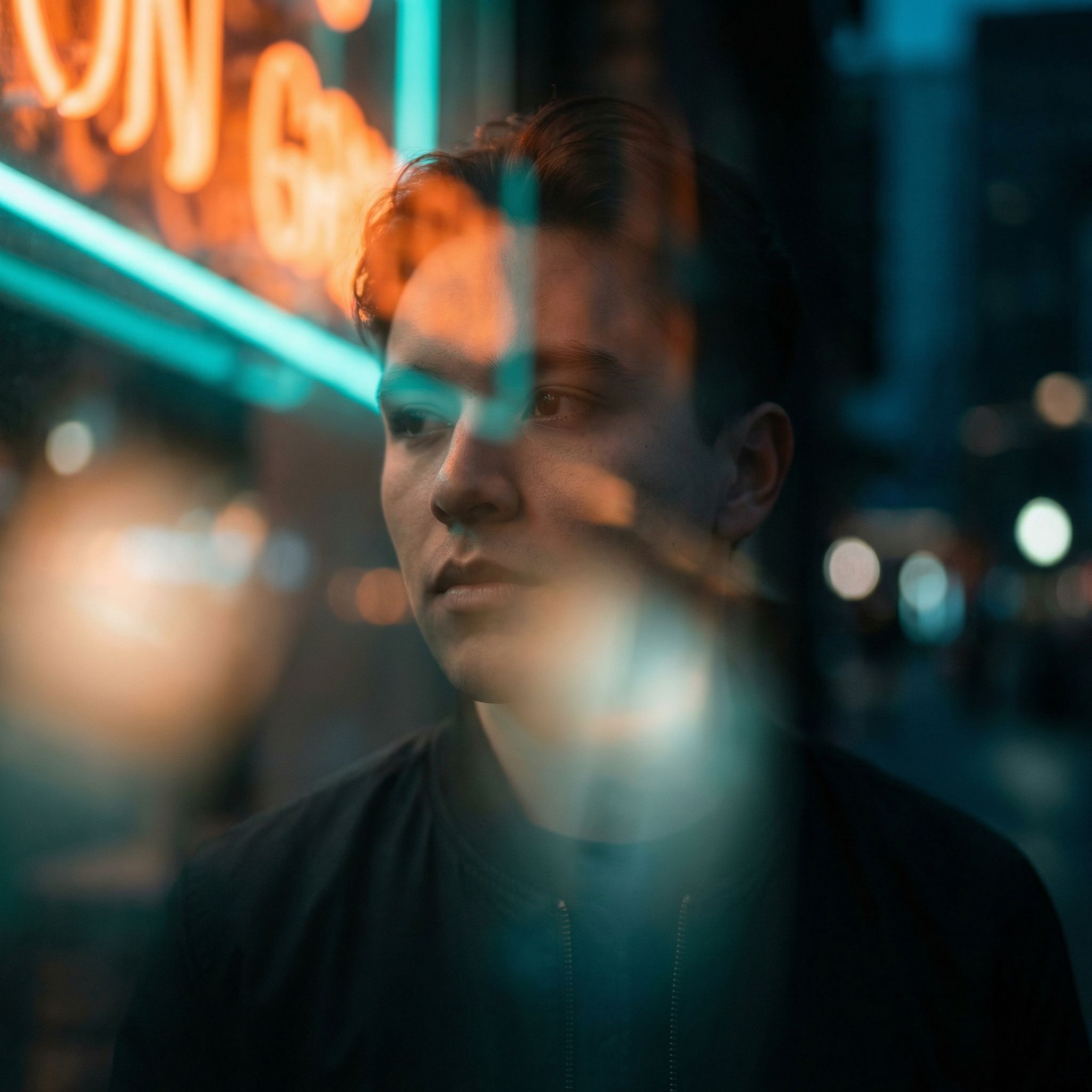 Moody portrait by neon window at night
