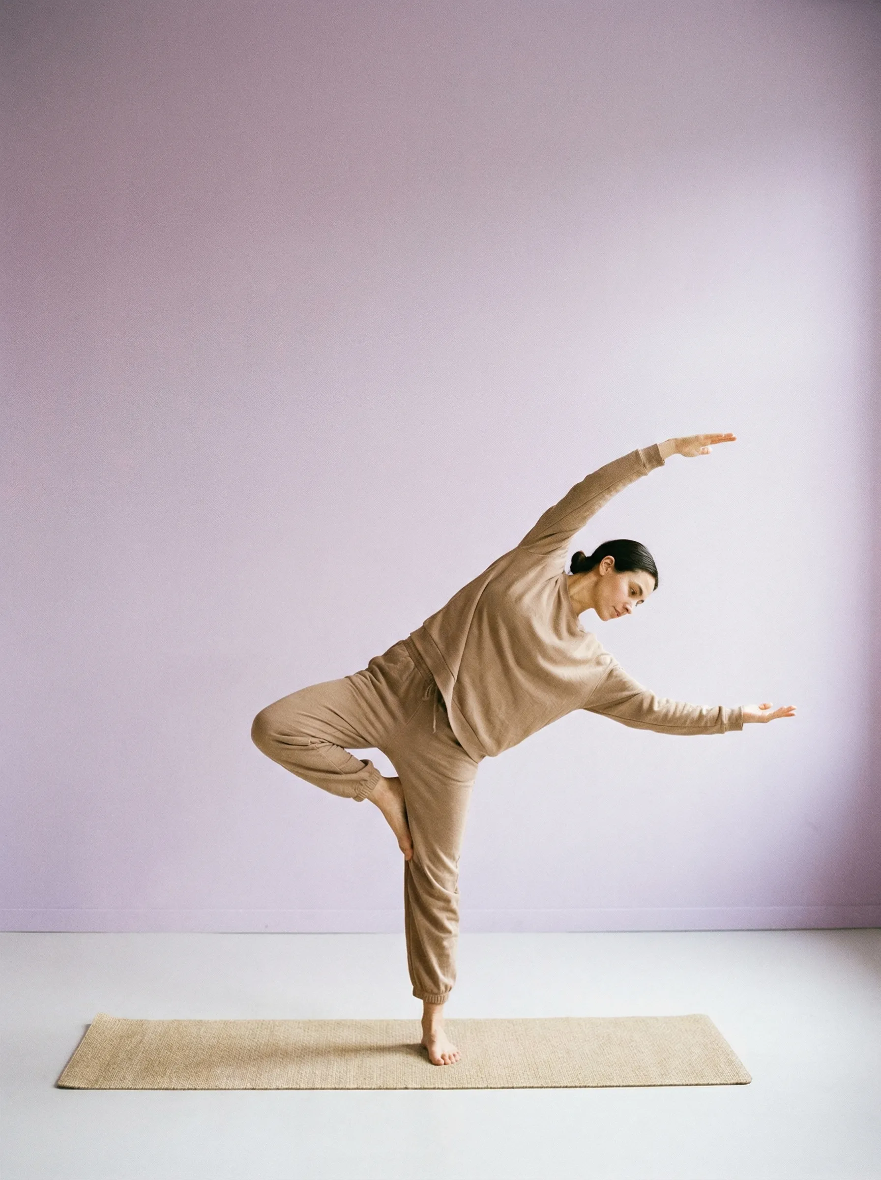Woman practicing yoga balance pose indoors