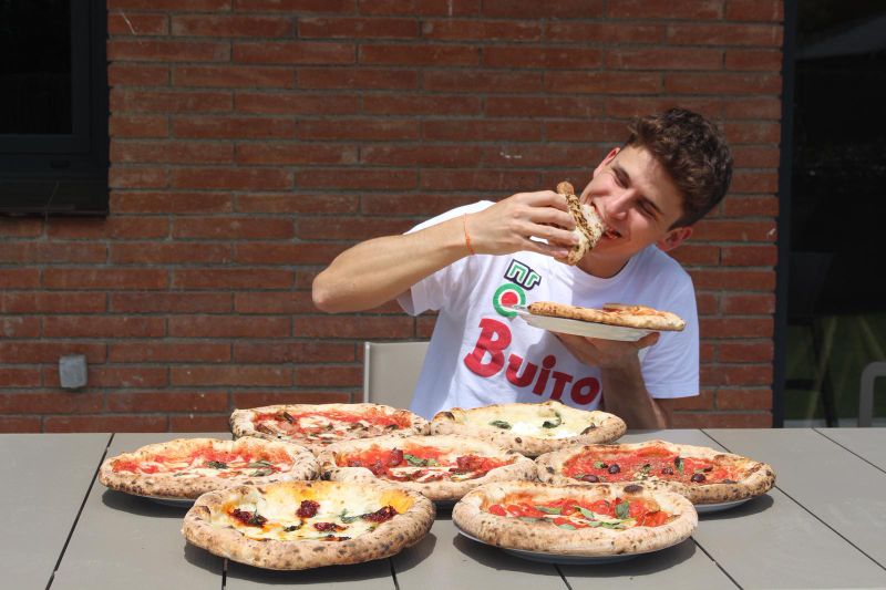 Young Man Enjoying Multiple Neapolitan Pizzas Outdoors