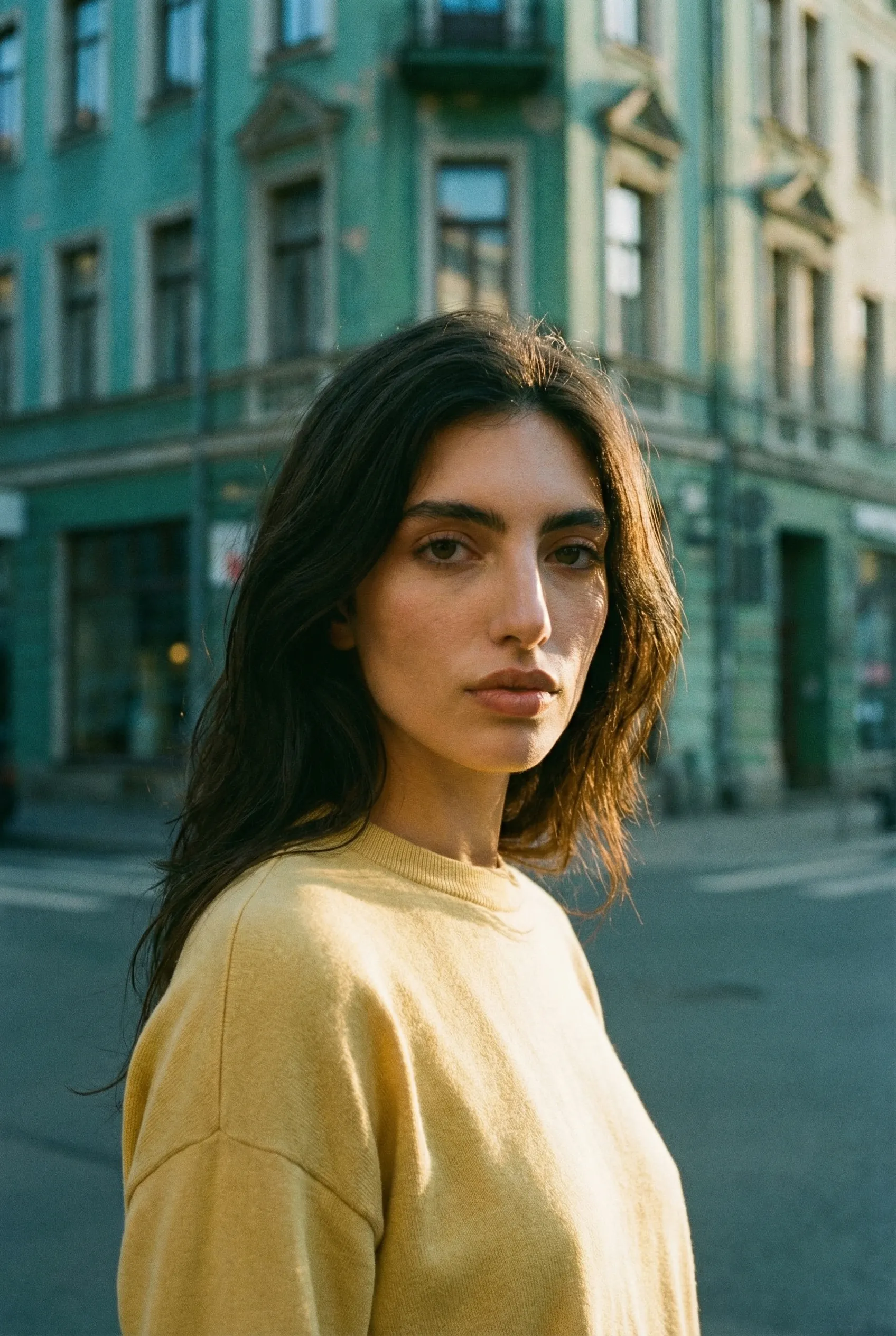 Pensive woman in yellow sweater on city street