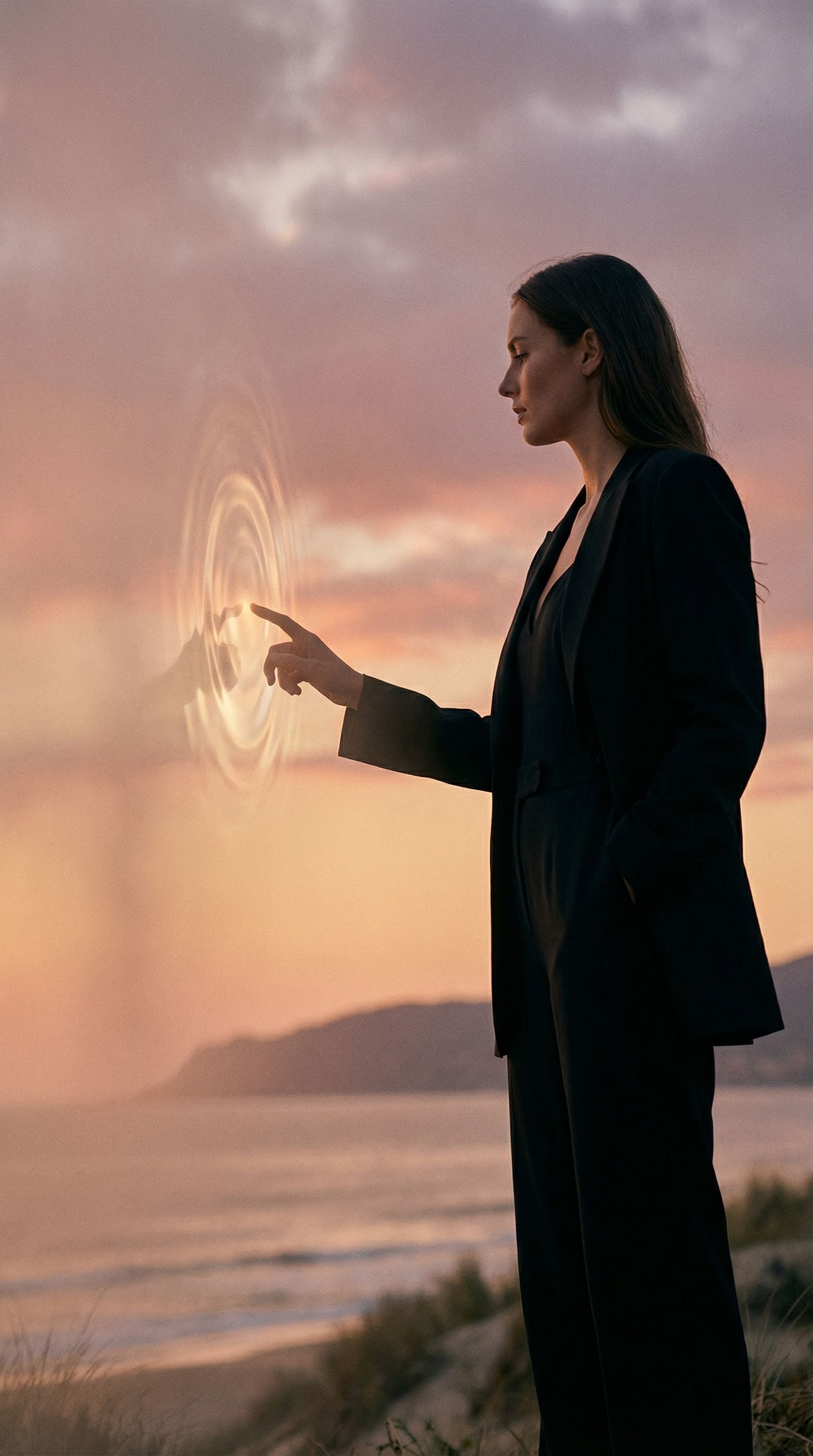 Businesswoman touching futuristic hologram at beach