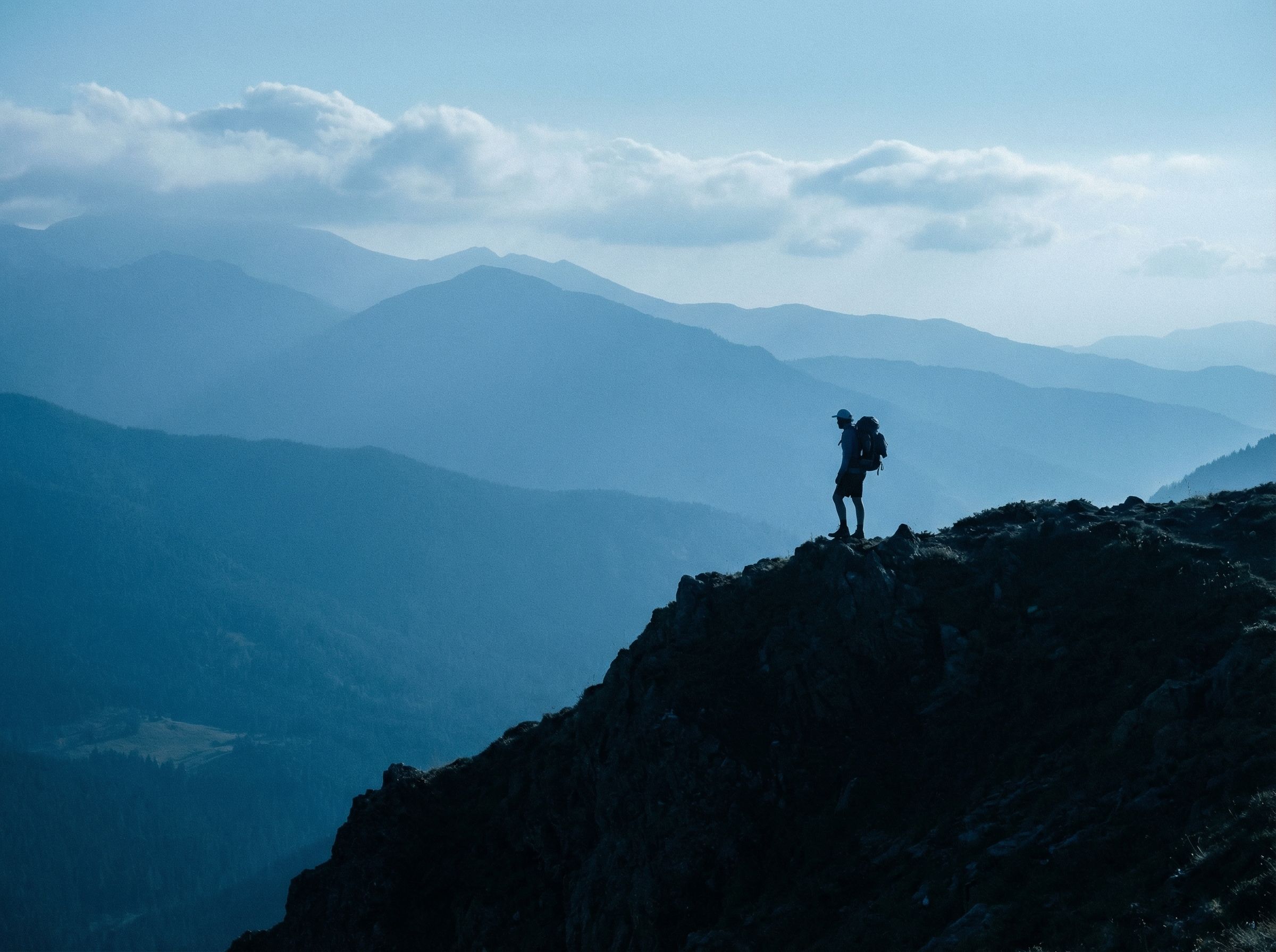 Hiker Silhouette on Mountain Ridge at Dusk