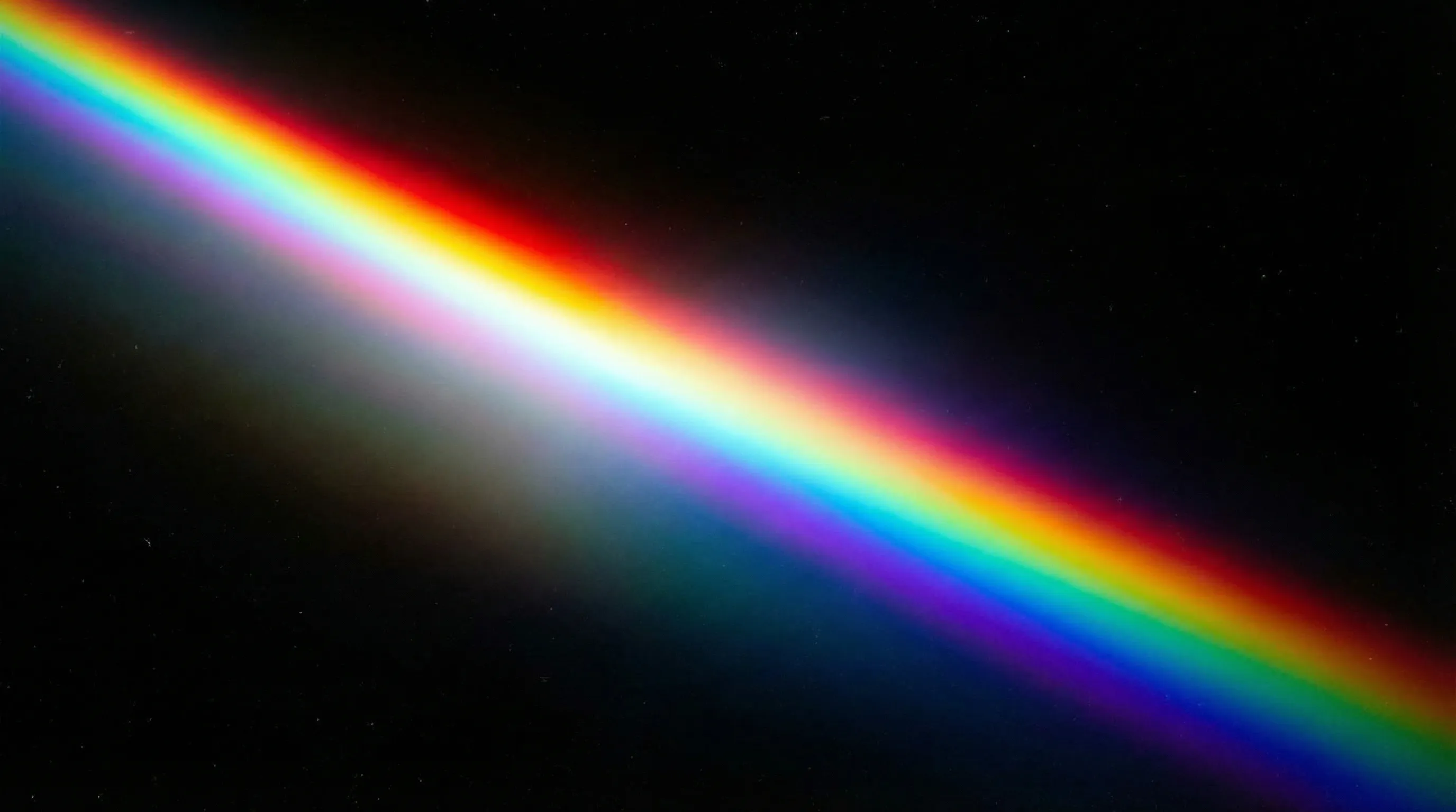Diagonal rainbow light on black background