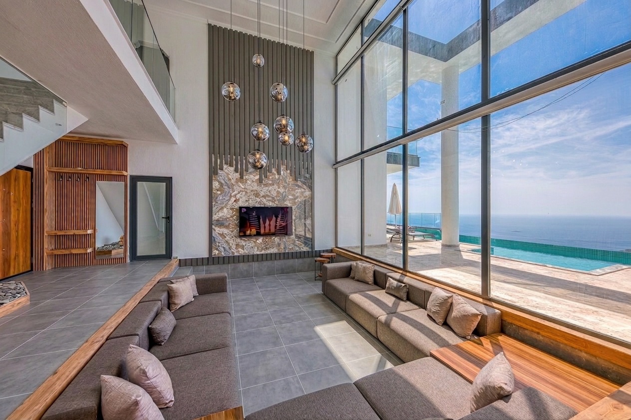 Villa interior with large-format porcelain floor and doors open to the view