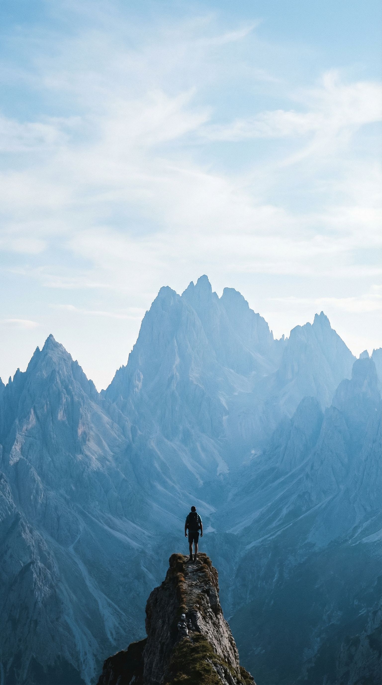 Lone hiker on mountain peak at sunrise