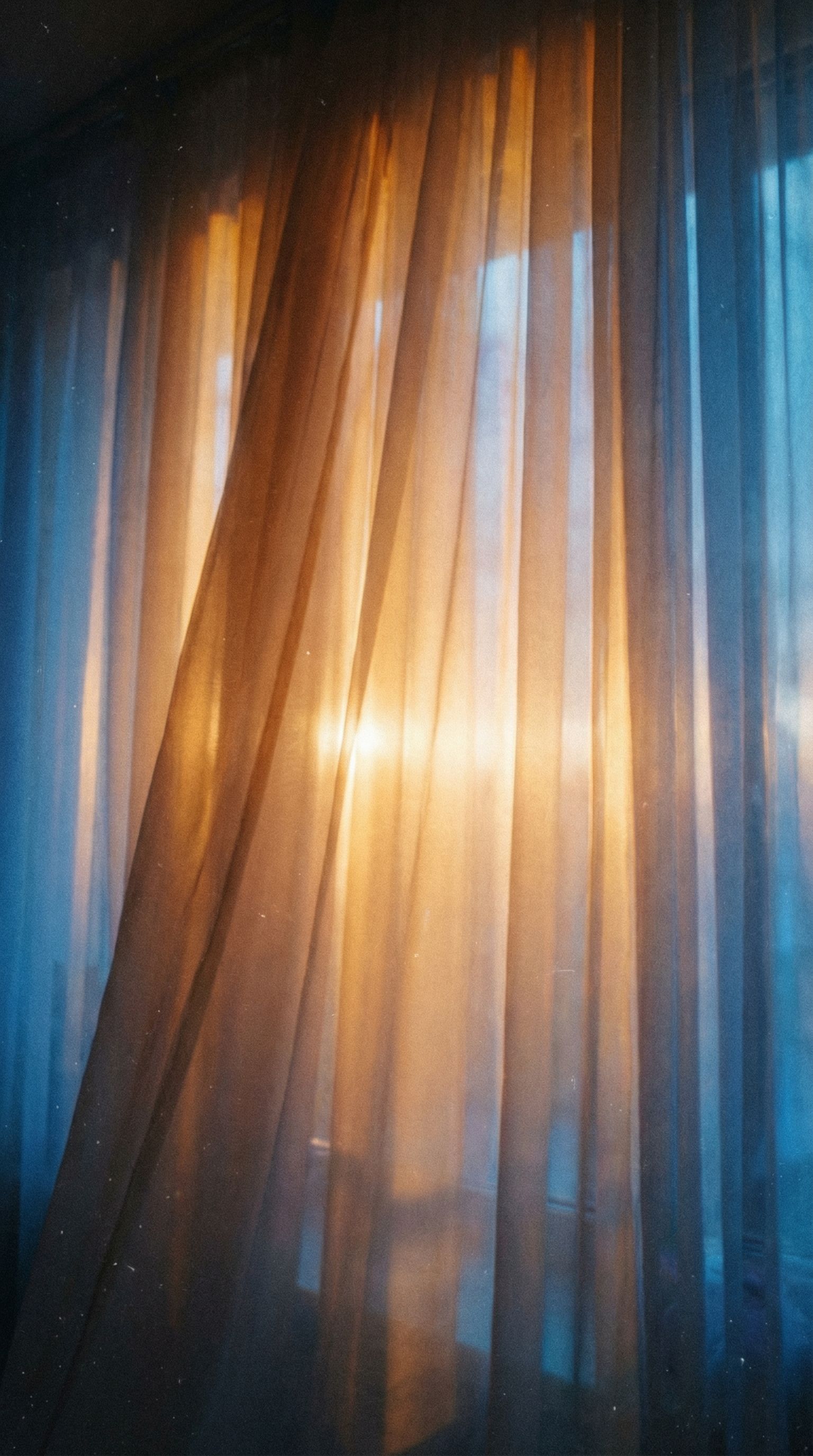 Warm light through sheer curtains