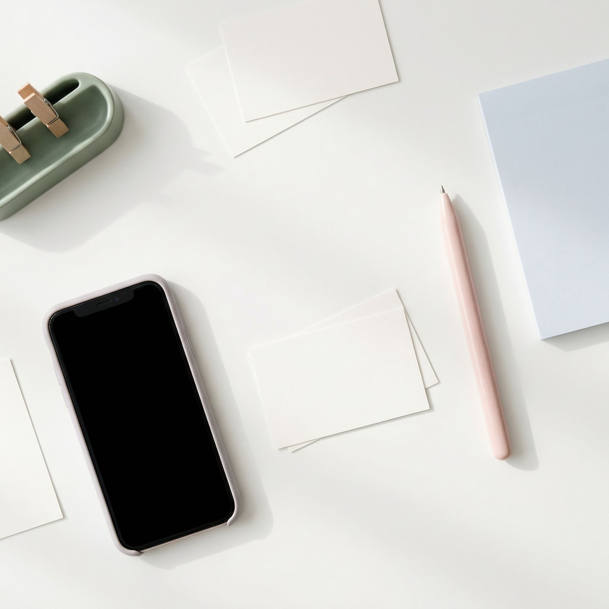 Minimal desktop with smartphone and stationery