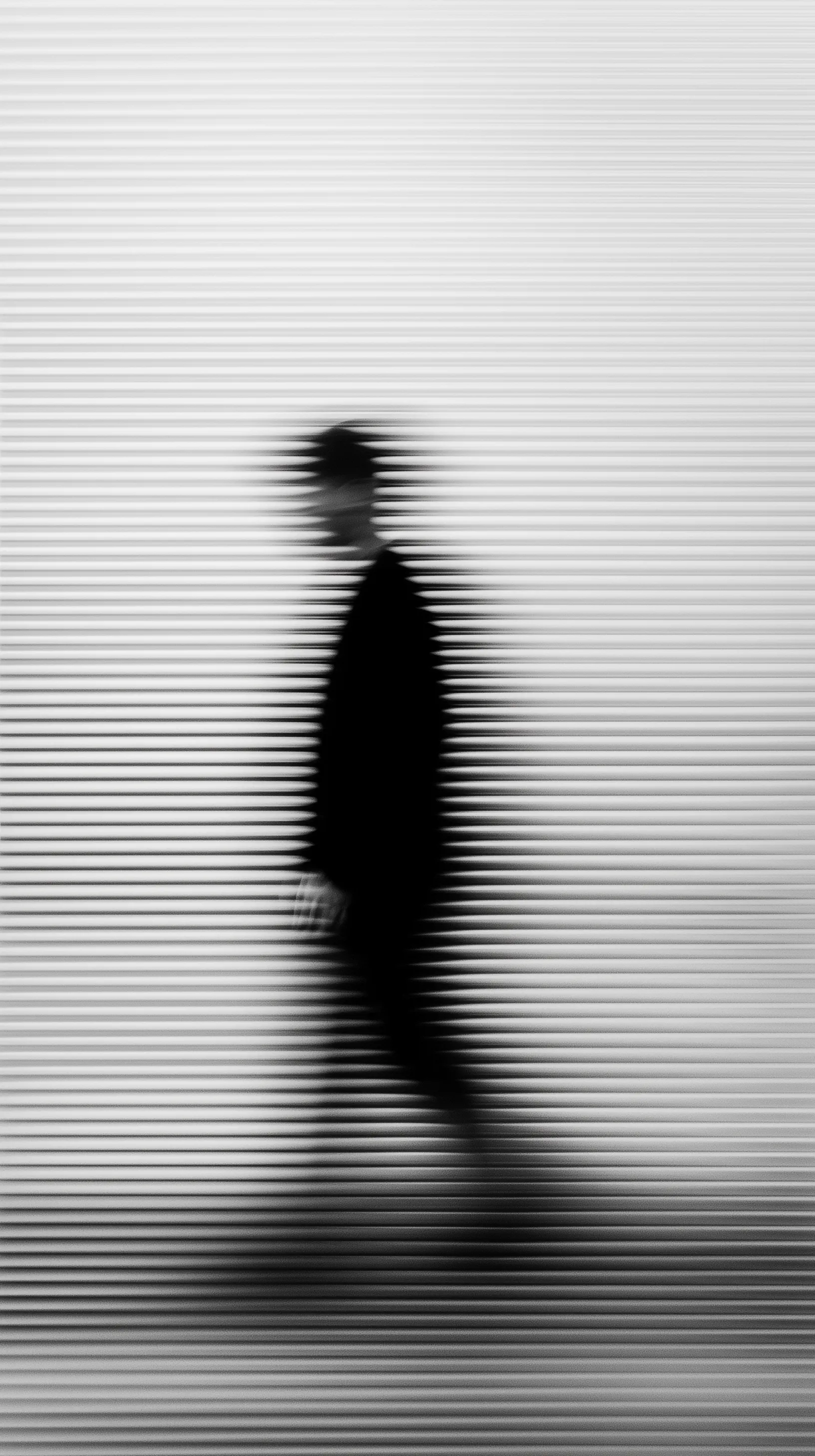 Abstract Motion Blur Silhouette behind Fluted Glass