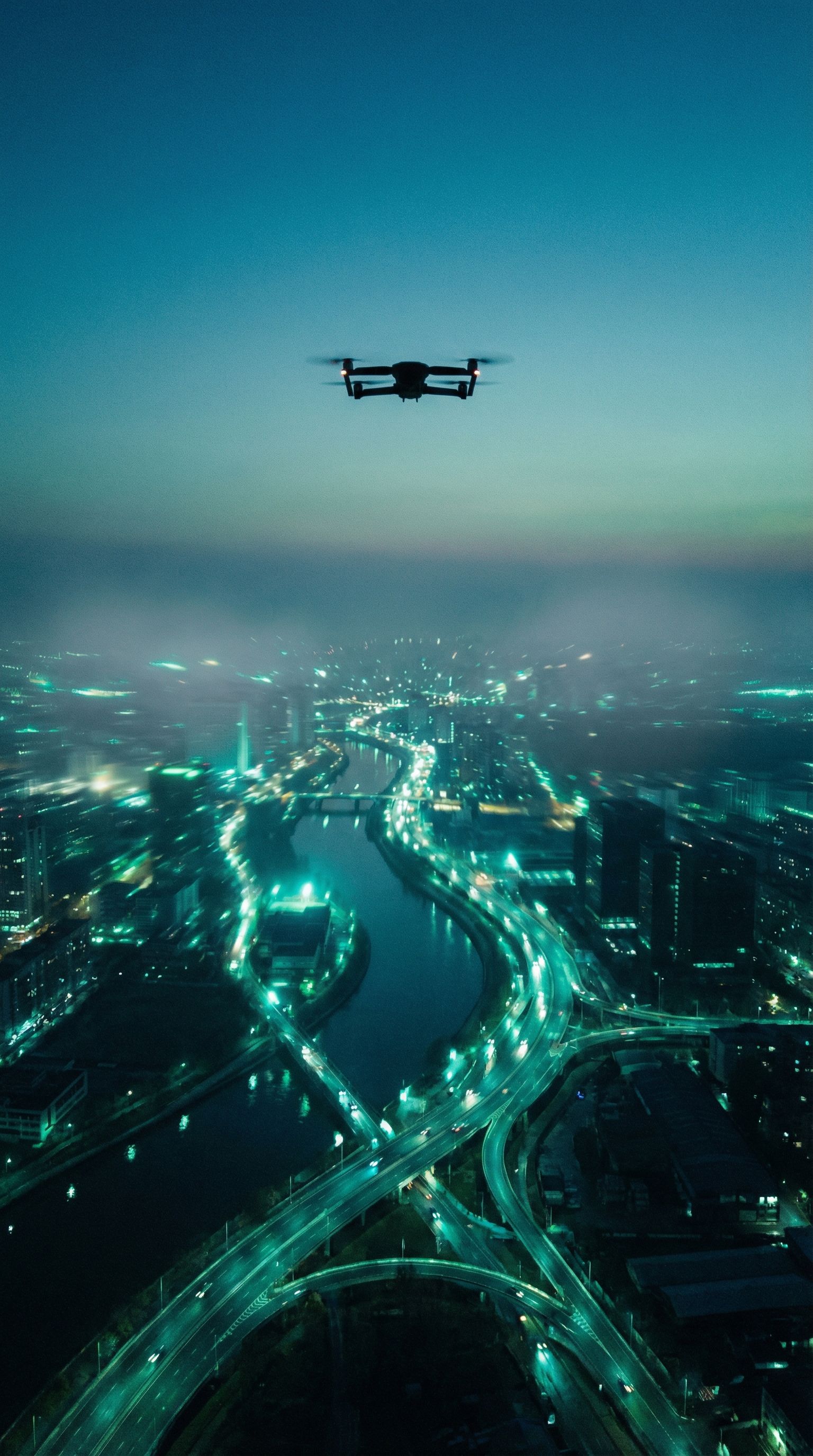 Drone over futuristic night cityscape