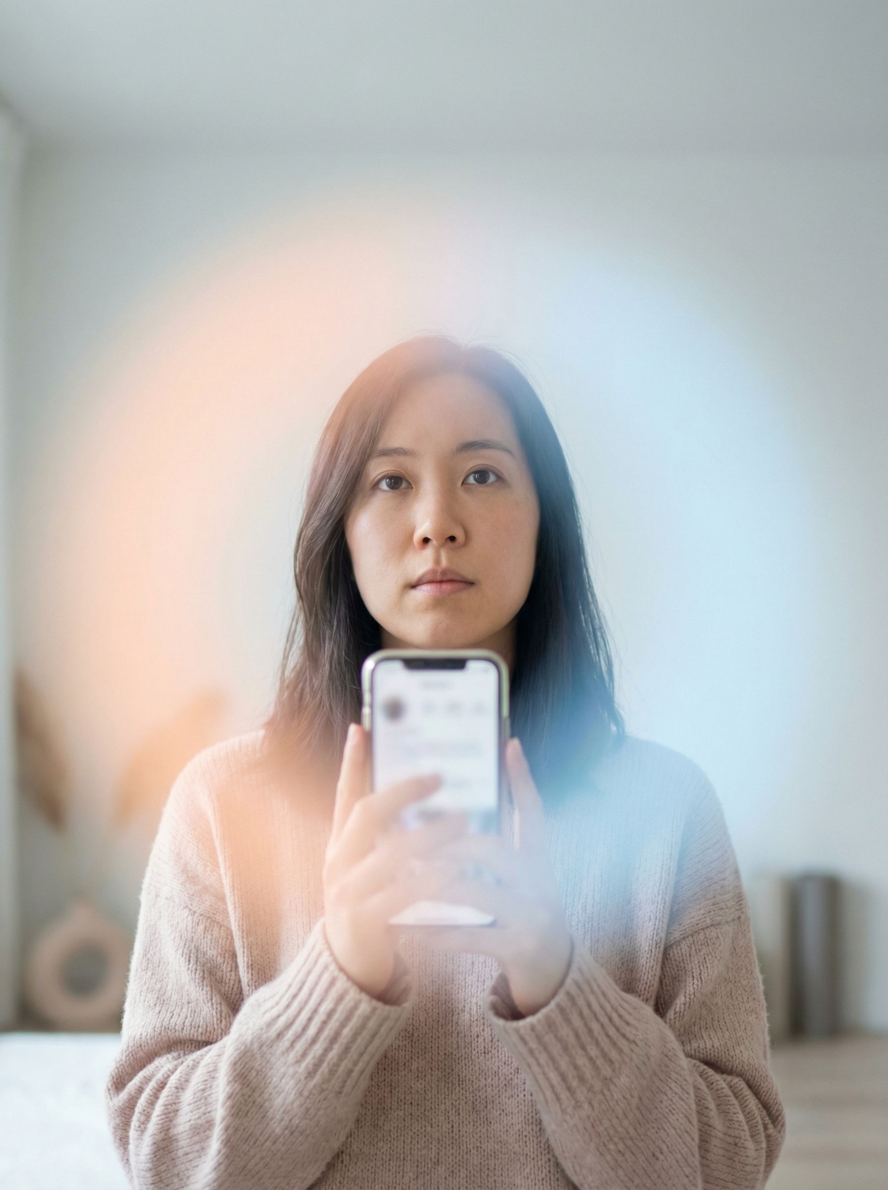 Woman holding smartphone with soft light flares