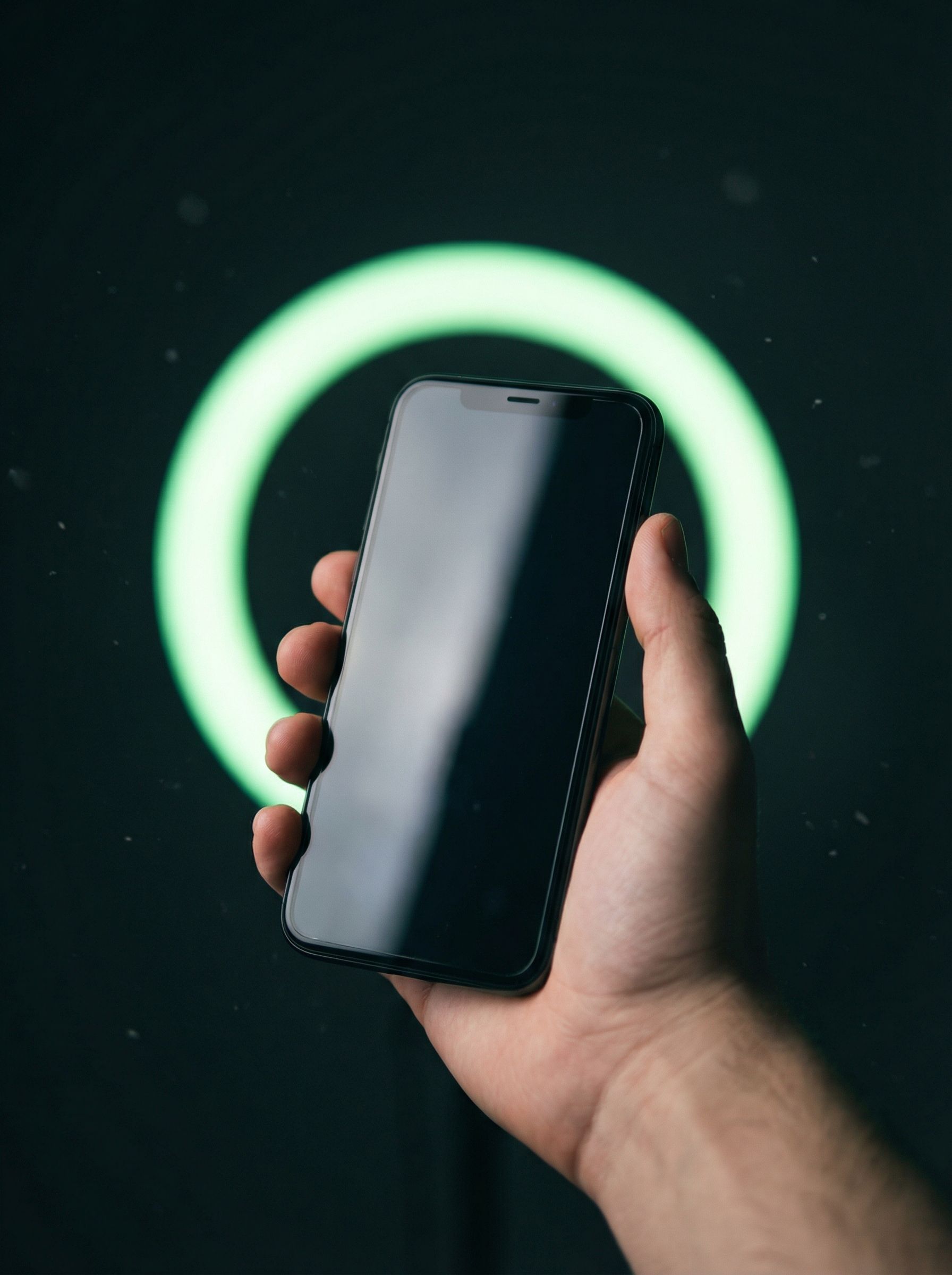 Hand holding smartphone with neon ring light