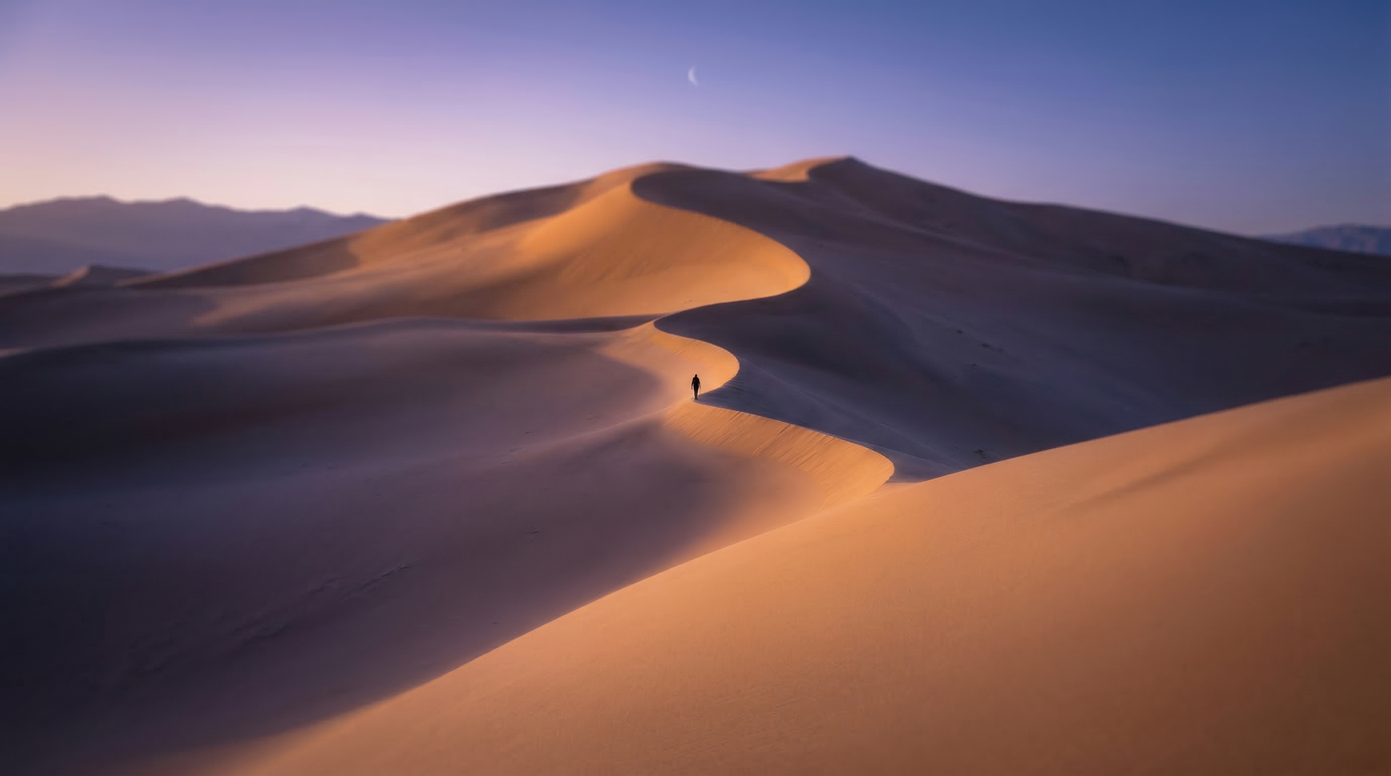 Lone Figure Walking Through Desert Dunes