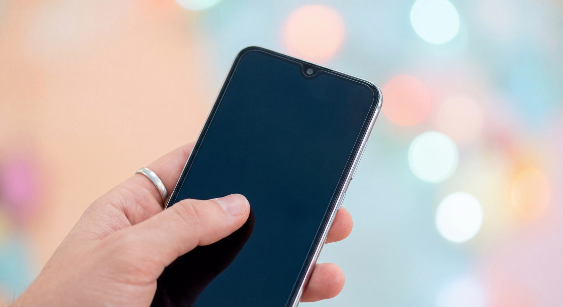Hand holding modern smartphone with blank screen