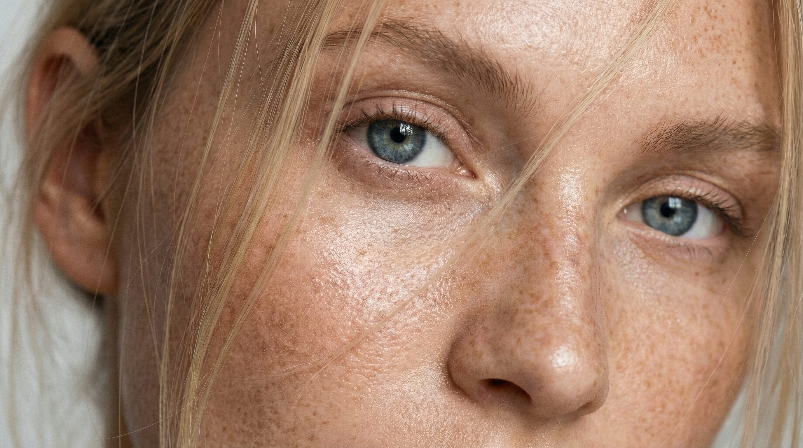 Close-up of freckled face with blue eye