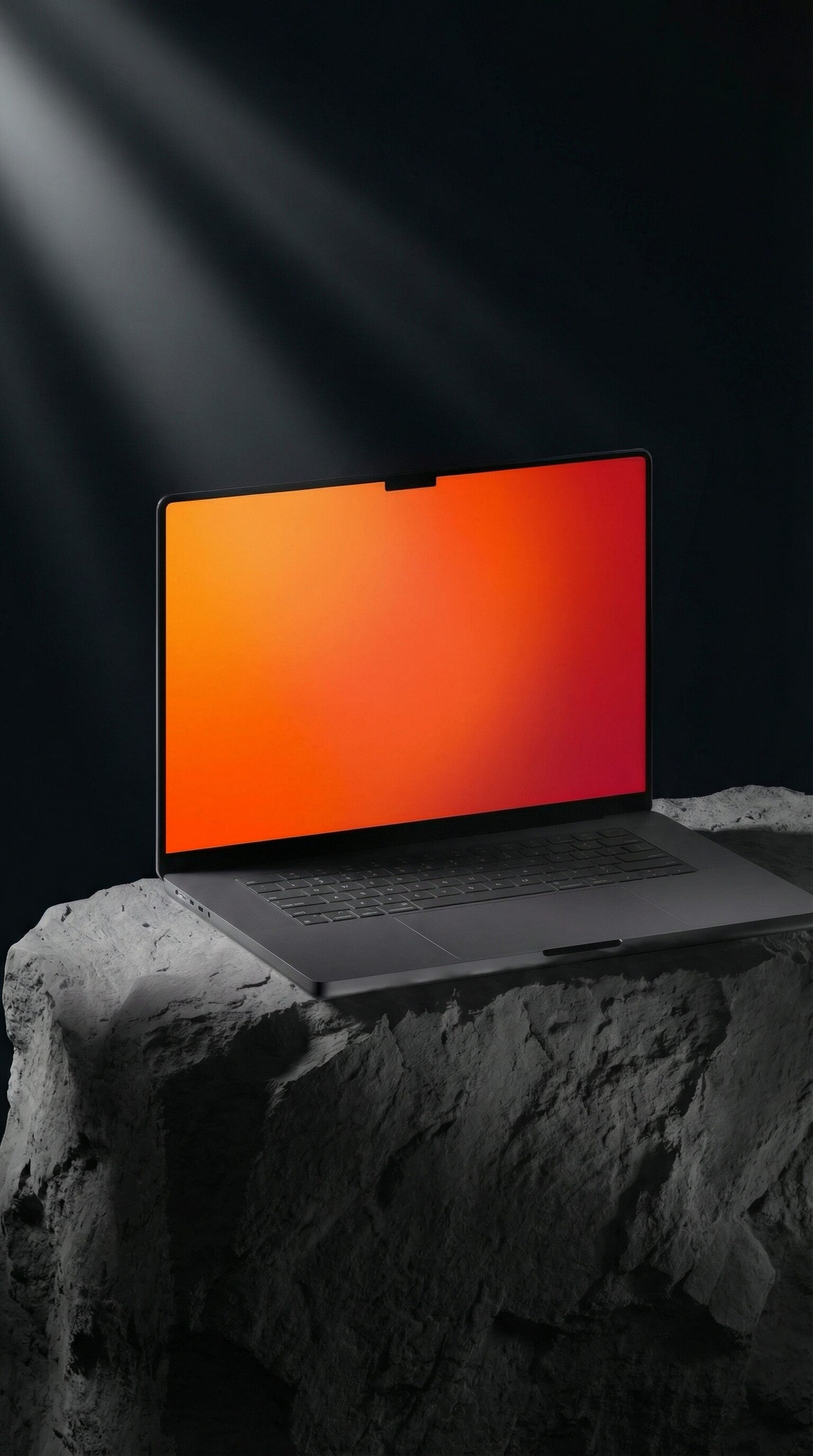 Laptop with orange screen on dark rock