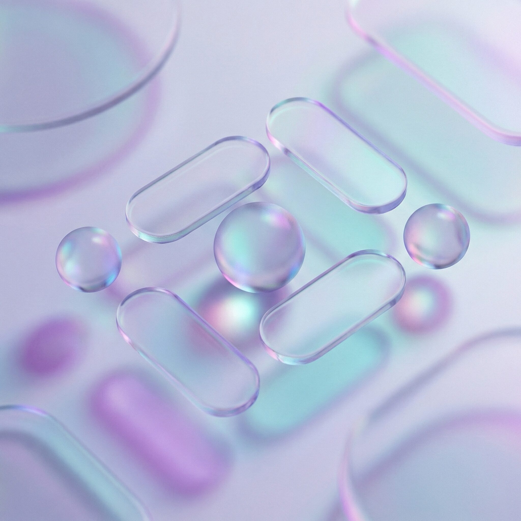 Iridescent glass pills and spheres on pastel